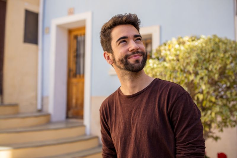 young hispanic man outdoors smiling