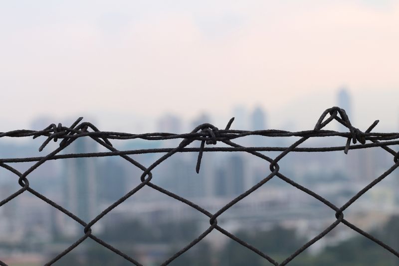 Barbed wire fence with view of city in the background