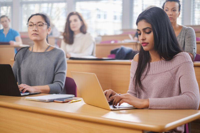 Multinational students taking notes in classroom