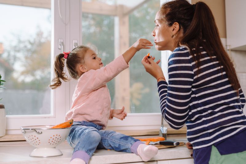 Young mother in the kitchen with her child