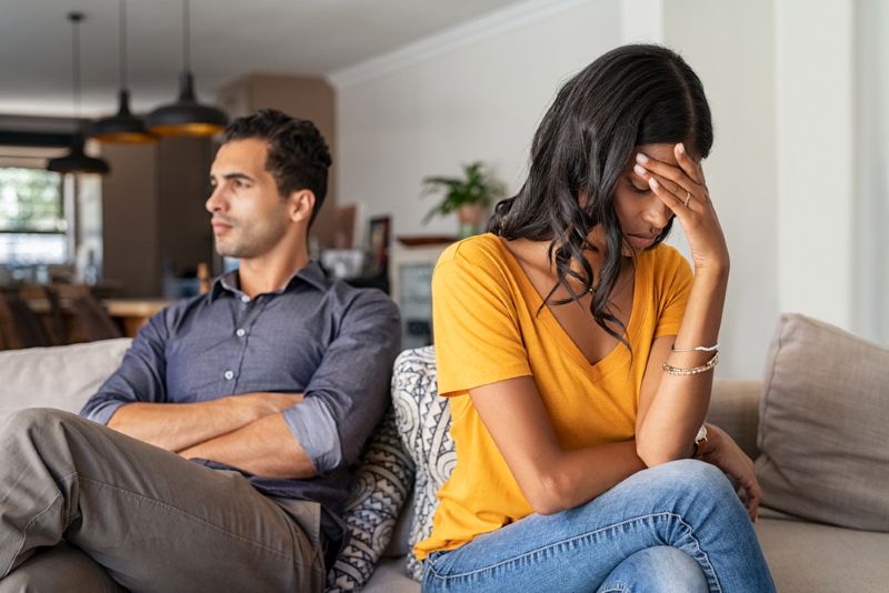 Worried immigrant couple on their couch