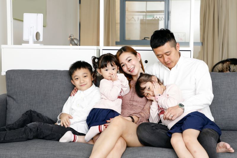 Asian family posing on the couch for family photo